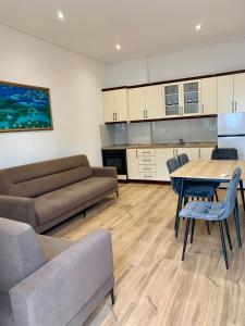 a living room with a couch and a table and chairs at Duka Apts in Sarandë
