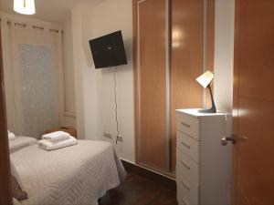 een slaapkamer met een bed en een dressoir met een lamp bij CASA vila in Riópar