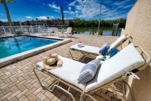 a pair of lawn chairs next to a swimming pool at Bayside Escape-Condo w Dock Pool and Near Beach in Sarasota
