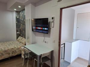 a small room with a table and a tv on the wall at TourismCasa in Dos Hermanas