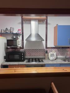 a kitchen with a microwave and a stove top oven at Apartamento Zahara in Zahara de los Atunes