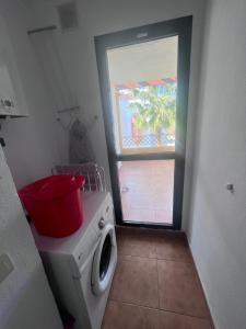 a laundry room with a washing machine and a window at Apartamento Zahara in Zahara de los Atunes