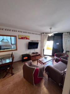 a living room with two couches and a flat screen tv at Apartamento Zahara in Zahara de los Atunes