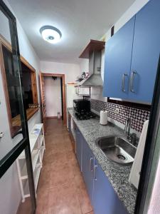 a kitchen with blue cabinets and a sink at Apartamento Zahara in Zahara de los Atunes