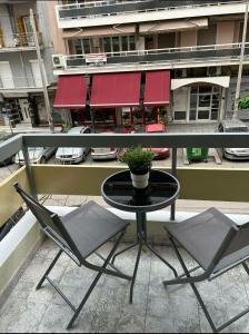 une table avec deux chaises et une plante en pot sur un balcon dans l'établissement MSK Rotonda Studio 2, à Thessalonique