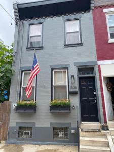 Una casa gris con una bandera americana. en Modern South Philly Townhome, en Filadelfia