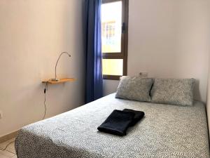 a bed with a black towel sitting on top of it at Casa Vega in Cotillo