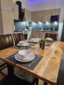 a kitchen with a wooden table with plates and wine glasses at Apartment Traumzeit - ebenerdige Wohnung in Gifhorn - Kästorf in Kästorf