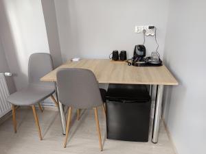 Anders Home 1 في شتشتنو: طاولة خشبية عليها ثلاثة كراسي ومكينة قهوة