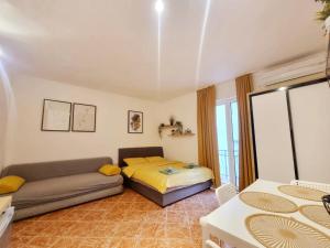 - un salon avec un lit et un canapé dans l'établissement Studio apartman na plaži, à Rafailovici