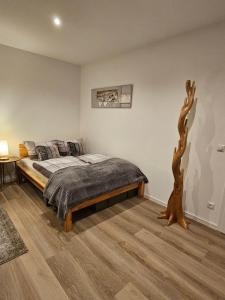 a bedroom with a bed and a tree branch on the wall at Apartment Traumzeit - ebenerdige Wohnung in Gifhorn - Kästorf in Kästorf