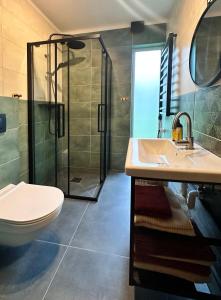 La salle de bains est pourvue d'une douche, d'un lavabo et de toilettes. dans l'établissement Żywiołowo - domki w stylu stodoły z placem zabaw i stawem - ZIEMIA, à Parchowo