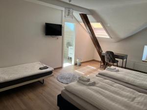 a room with two beds and a desk and a piano at Hotel Restaurant du Moulin in Fleurier