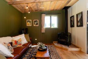 a living room with a couch and a wood stove at Self contained romantic Farmstay in Waipara wine country with bath and fire in Waipara