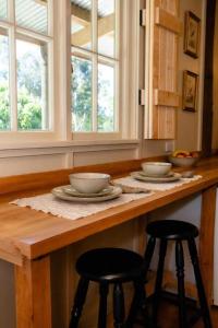a kitchen with two stools at a counter with two bowls at Self contained romantic Farmstay in Waipara wine country with bath and fire in Waipara