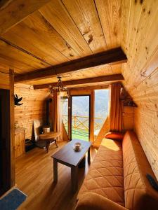 a living room with a couch and a table at cottage panorama merisi in Inasharidzeebi