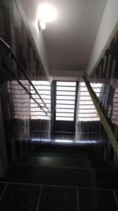 eine Treppe in einem Gebäude mit einigen Fenstern und einem Licht in der Unterkunft Casa Bela Vista da Serra da canastra in São Roque de Minas