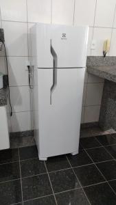 a white refrigerator in the corner of a kitchen at Casa Bela Vista da Serra da canastra in São Roque de Minas