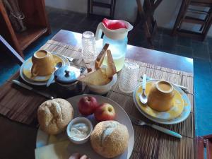 a table with plates of food and cups of tea at Recanto das Bromélias Chalés in Guarda do Embaú
