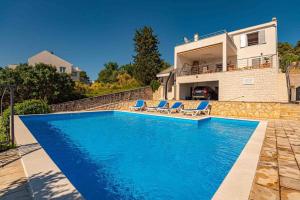 a swimming pool in front of a house at Amazing Mediterranean view Villa Oliva Zaboric in Zaboric