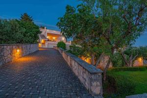 a stone path leading to a house with a stone wall at Amazing Mediterranean view Villa Oliva Zaboric in Zaboric