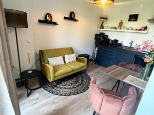 a living room with a yellow chair and a table at The West Wing Bloemendaal in Bloemendaal