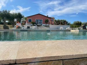 a swimming pool with a house in the background at Agriturismo il maniero in Ancona