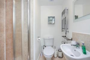 a bathroom with a toilet and a sink and a shower at Vibrant Clapham Double bedroom in London