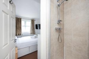 a bathroom with a shower and a bedroom at Vibrant Clapham Double bedroom in London