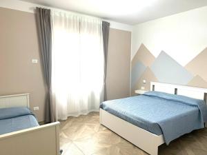 a bedroom with two beds and a window with mountains at civico 250 in Pescara