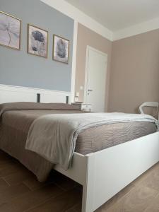 ein weißes Schlafzimmer mit einem großen Bett mit zwei Bildern an der Wand in der Unterkunft civico 250 in Pescara