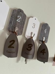 vier verschiedene Nummern auf Holzmarken an einer Wand in der Unterkunft civico 250 in Pescara