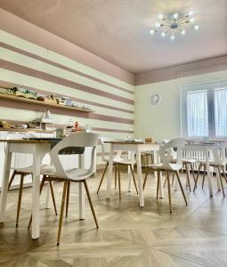 ein Esszimmer mit weißen Tischen und weißen Stühlen in der Unterkunft civico 250 in Pescara