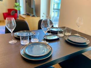 a table with plates and wine glasses on it at Cozy Residence Apartment - Tallinn City Center in Tallinn