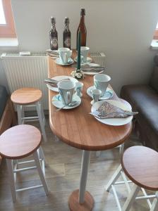 a wooden table with cups and saucers on it at Apartment Bräustübel, free Wi-Fi, Parken, Grillecke, nähe Rennsteig in Lehesten +28 photos