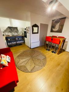 sala de estar con sofá rojo y nevera blanca en No 14 , 15 meters plein centre Mirepoix apartment Très Calme Netflix ,Terrace Sleeps 4 70 m2 en Mirepoix