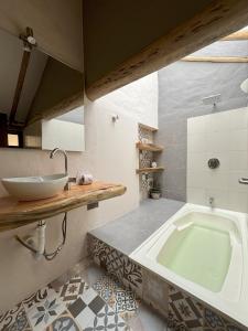 a bathroom with a tub and a sink at ApartaHotel La Leyenda in Villa de Leyva