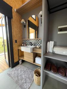 ein Bad mit einem Waschbecken und einem Spiegel in der Unterkunft Soular Lodge e Fazenda in São Francisco de Paula