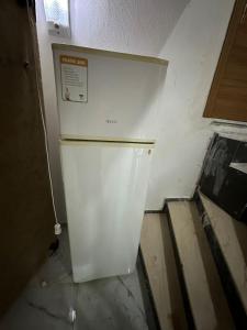 einen weißen Kühlschrank in einer Ecke eines Zimmers in der Unterkunft Nr1 Pansiyon in Canakkale