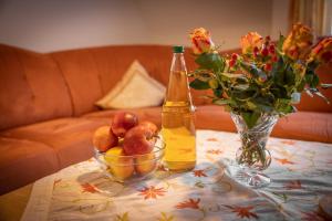 un tavolo con una bottiglia di birra e un cesto di frutta di Gästehaus zum Landesteg a Immenstaad am Bodensee