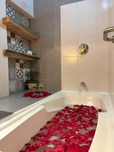una bañera llena de pétalos de rosas rojas en ApartaHotel La Leyenda, en Villa de Leyva