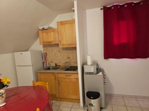 una piccola cucina con un frigorifero e una tenda rossa di Appartement calme bien équipé a Lèves Altre 21 foto