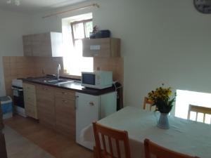 a kitchen with a table and a sink and a microwave at ROSE COTTAGE (sleeps 4) in Chlum u Třeboně