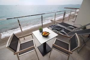 a table and chairs on a balcony with the ocean at Villa Azur in Villeneuve-Loubet