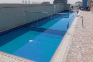 a swimming pool with blue water on top of a building at King Bed Condo in Dubai Sports City with Pool, Sauna, Fast Wi-Fi in Dubai