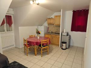 a small kitchen with a table and chairs in a room at Logement calme bien équipé in Lèves