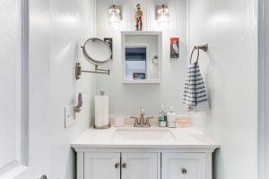 une salle de bain blanche avec un lavabo et un miroir dans l'établissement Lake Marion Home Kayaks, Dock, Waterfront Fun!, à Summerton 27 autres photos