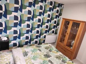 1 dormitorio con 1 cama y una pared colorida en Maison de campagne, en Norrois 3 fotos más