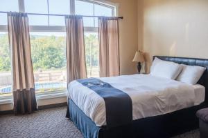 a bedroom with a bed and a large window at Williamsport Grandview Hotel in Linden