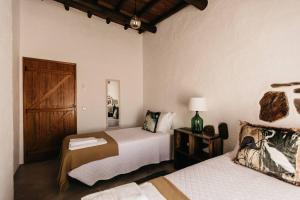 een slaapkamer met 2 bedden en een houten deur bij Casa do Sossego Monsaraz in Reguengos de Monsaraz